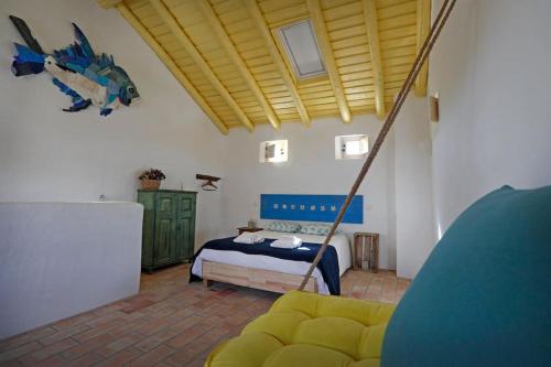 a bedroom with a bed and a couch in a room at Casa Amado, Aldeia da Pedralva in Vila do Bispo