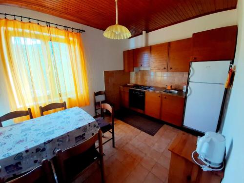 Kampor的住宿－House Branka，厨房配有桌子和白色冰箱。