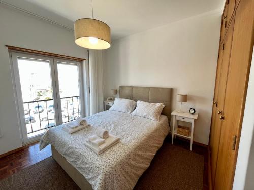 ein Schlafzimmer mit einem Bett mit zwei Handtüchern darauf in der Unterkunft Casa da Estação_São Martinho do Porto in São Martinho do Porto
