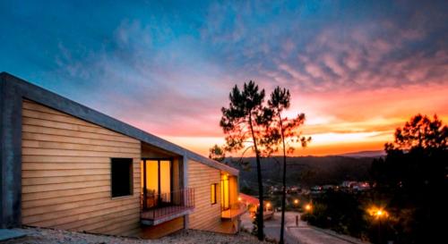 a small building with a sunset in the background at Casas do Almourão in Foz do Cobrão