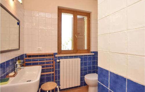 een badkamer met een wastafel, een toilet en een raam bij Stunning Home In Toffia With Outdoor Swimming Pool in Toffia