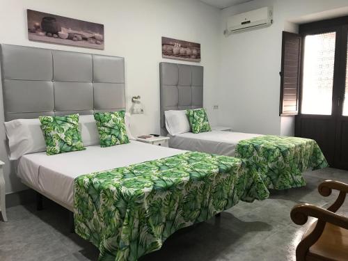 1 dormitorio con 2 camas con sábanas verdes en La Casa en el Centro en Écija