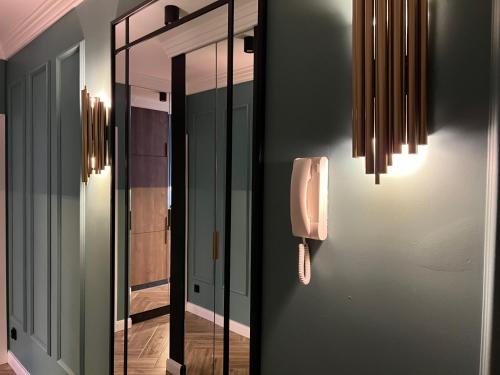 pasillo con espejo y teléfono en la pared en Family & Business Sauna Tężnia Apartments No 10 VIP -Leśny nad Zalewem Cedzyna, Unikat SPA- 1 Bedroom with Private Sauna, Jacuzzi, Spectacular View Terrace, Parking, Catering Options, en Kielce