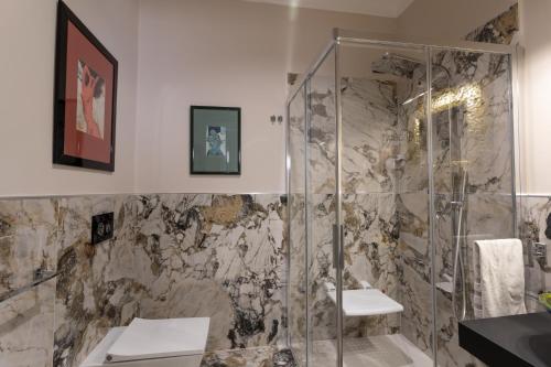 ein Bad mit einer Dusche und einem Waschbecken in der Unterkunft Domus Clelia Paestum Antica Luxury rooms in Paestum
