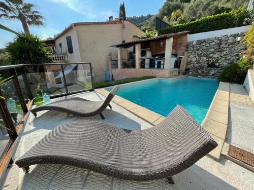 un patio avec deux chaises et une piscine dans l'établissement Charmant rez de villa en provence, à Le Tignet