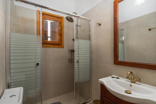 a bathroom with a shower and a sink and a mirror at Granny's Yard in Adamas