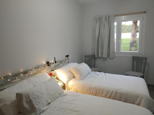 two beds in a room with lights and a window at Apartamentos Meruelo in San Miguel de Meruelo