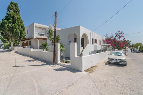 a car parked in front of a white house at Granny's Yard in Adamas