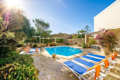 a swimming pool with lounge chairs at Sulda Brill in Nadur