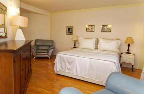 - une chambre avec un lit et une chaise dans l'établissement Apartment Levarda with private hydromassage pool, à Okrug Gornji