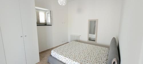 een witte slaapkamer met een bed en een raam bij Casa Eoliana in Lipari