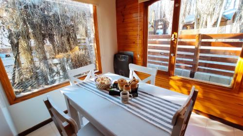 埃爾卡拉法特的住宿－La Comarca Azul，一张带椅子的白色桌子和泰迪熊
