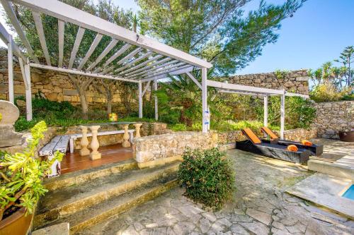 a patio with a bench and a pergola at Sulda Brill in Nadur