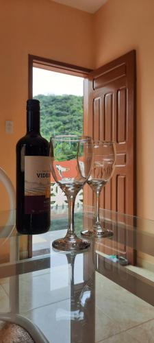 a bottle of wine and two wine glasses on a counter at Casa DeTe Caldas-Barbalha in Barbalha
