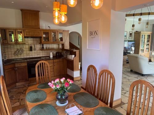 a kitchen with a table with a vase of flowers on it at Zakole Brdy in Gostycyn
