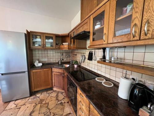 a kitchen with wooden cabinets and a stainless steel refrigerator at Zakole Brdy in Gostycyn
