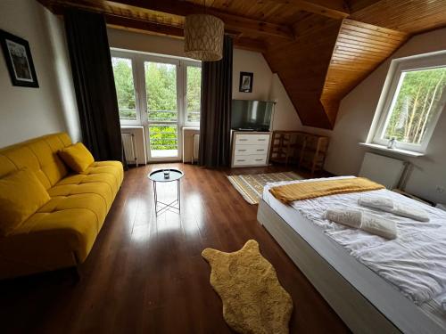 a bedroom with a large bed and a couch at Zakole Brdy in Gostycyn