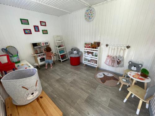 a room with a little girl standing in a room at Zakole Brdy in Gostycyn