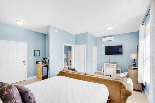 een slaapkamer met blauwe muren en een bed met een bank bij Village of South Walton B377-G in Rosemary Beach