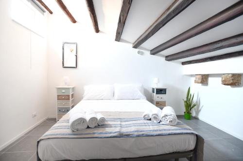 a white bedroom with a bed with towels on it at iFlat Residenza Libertà ai giardini del centro in Palermo
