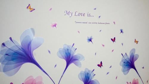 a painting of flowers and butterflies on a wall at Sakura Home in Batu Ferringhi