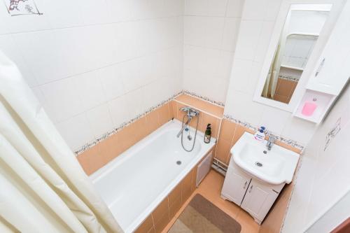 een badkamer met een bad en een wastafel bij Самал с красивым видом из окна in Alma-Ata