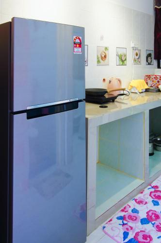 a refrigerator in a kitchen next to a counter at Sakura Home in Batu Ferringhi