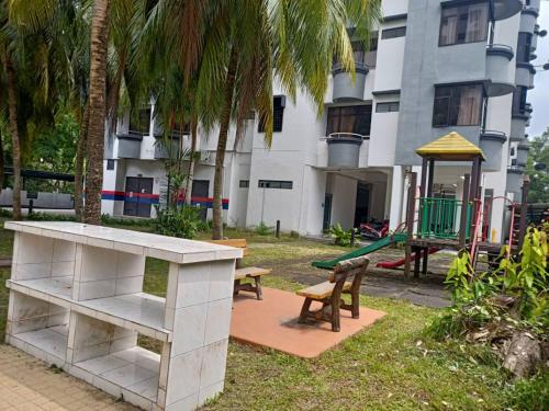 a playground in front of a building with a table and benches at Sakura Home in Batu Ferringhi