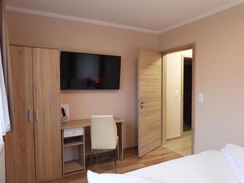 a bedroom with a desk and a tv on the wall at Nockalm Cottage in Bad Kleinkirchheim