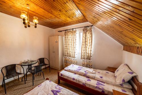 a bedroom with a bed and a table and chairs at SNAM Rooms&Apartment in Žabljak