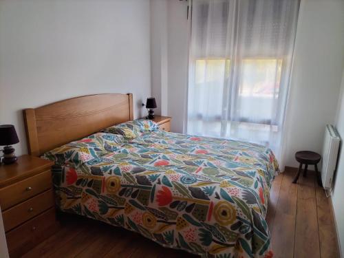 1 dormitorio con 1 cama con colcha colorida y ventana en Montes de Lillo, en Puebla de Lillo