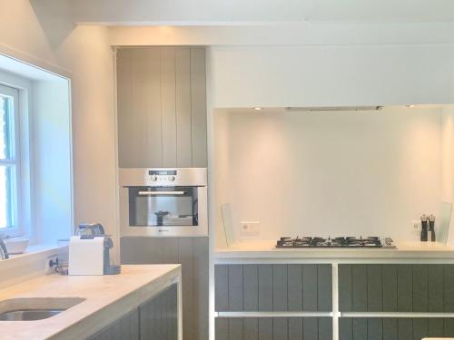 a kitchen with a sink and a stove top oven at The Green House Lodge in Den Dungen