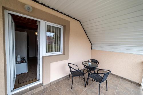 a porch with two chairs and a table and a window at SNAM Rooms&Apartment in Žabljak