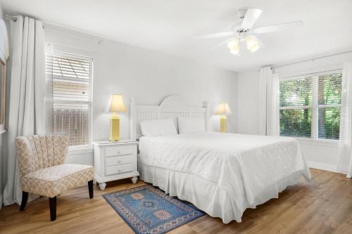 1 dormitorio blanco con 1 cama y 1 silla en Sandy Pelican, en Destin