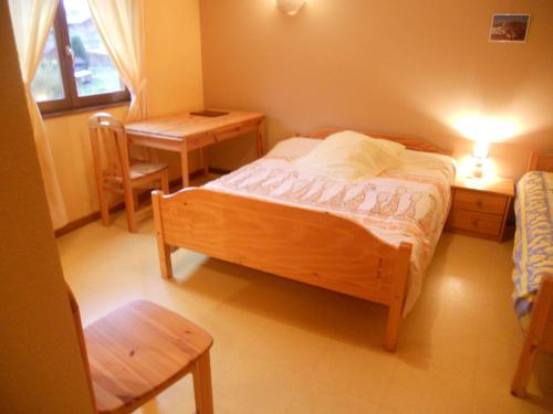 a bedroom with a bed and a table and a desk at Auberge du Saut des Cuves in Xonrupt-Longemer
