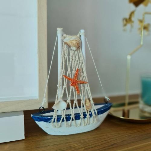 a toy boat with a starfish and other items on a table at Chelona Beachfront Huahin in Khao Tao