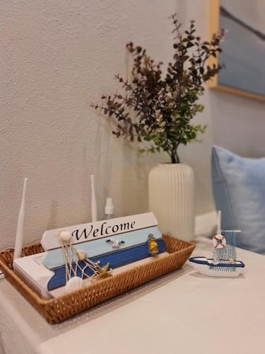 a welcome basket sitting on a table with a vase at Chelona Beachfront Huahin in Khao Tao