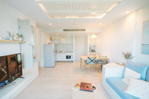 ein Wohnzimmer mit einem blauen Sofa und einem Tisch in der Unterkunft Chelona Beachfront Huahin in Khao Tao