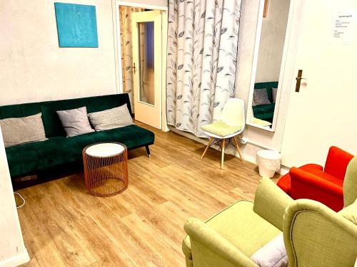 a living room with a green couch and chairs at Munich Aparthotel in Munich