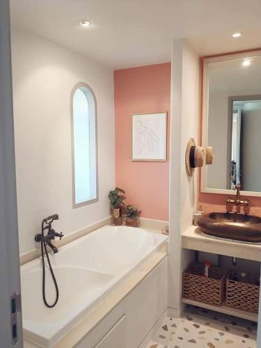 a bathroom with a large tub and a sink at Chelona Beachfront Huahin in Khao Tao