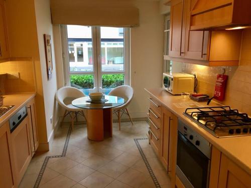cocina con mesa y mesa pequeña con sillas en Hopetoun Apartment with free parking en Edimburgo
