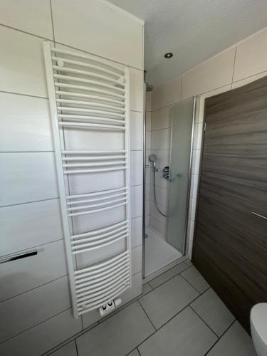 a bathroom with a shower and a toilet and a sink at Meerzeit Strandhotel in Neuharlingersiel