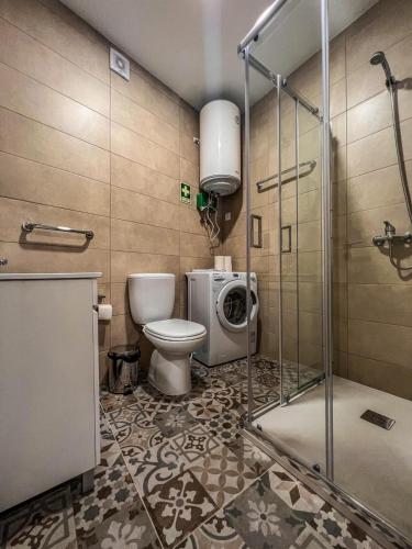 a bathroom with a toilet and a washing machine at Comfort Tua in Mirandela