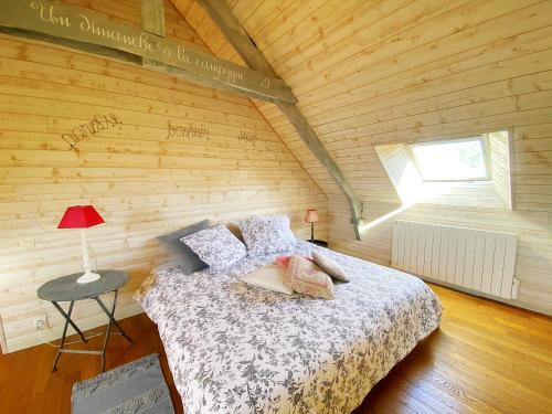a bedroom with a bed in a wooden wall at AU COEUR DE LA NATURE in Allaire