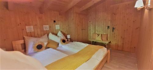 a bedroom with two beds in a wooden room at Luxusapartment im Landhaus Brugger in Mühlbach