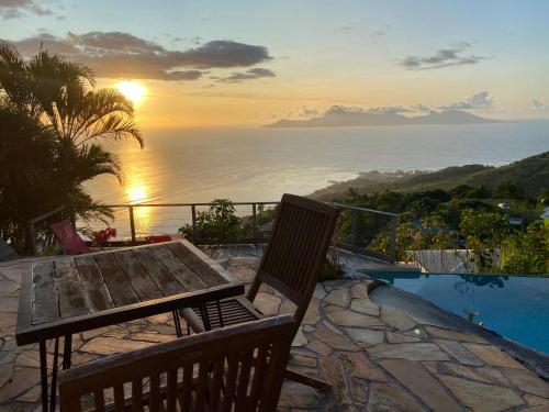 a table and chairs on a patio with a view of the ocean at Globe trotter Lodge Tahiti in Punaauia