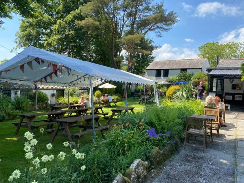 a group of people sitting at tables in a garden at The Crown Inn in Lanlivery