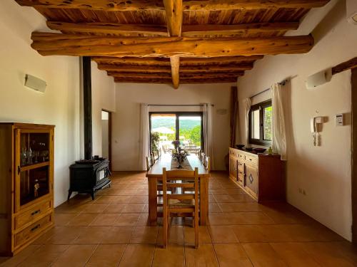 cocina con techos de madera, mesa y sillas en Can Marsá de Baix, en Santa Eulària des Riu