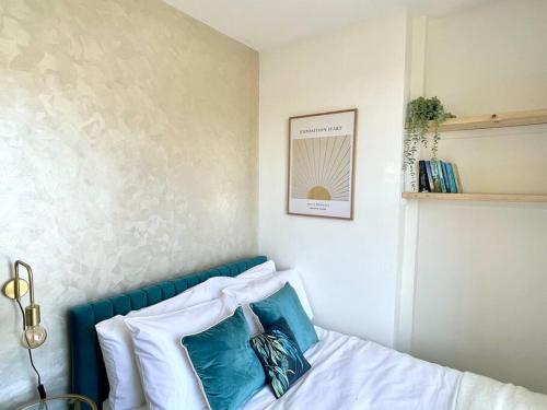 een slaapkamer met een bed met blauwe en witte kussens bij 3-Bed Luxe Truro Townhouse Gem. Escape in Style! in Truro