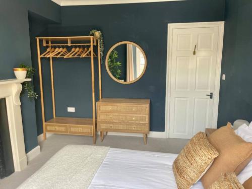 a bedroom with blue walls and a mirror and a bed at 3-Bed Luxe Truro Townhouse Gem. Escape in Style! in Truro